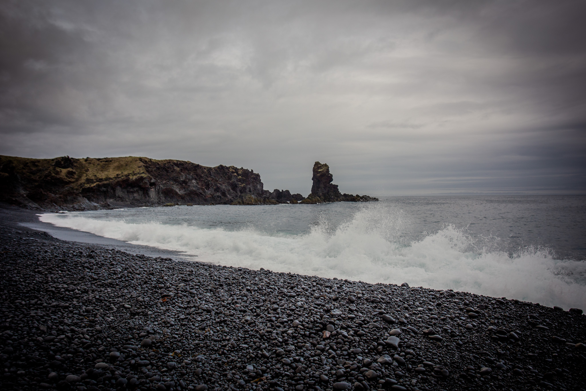 Black pebble beach with crashing waves